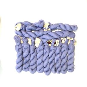 13 skeins of Classic Elite periwinkle wool and viscose (rayon) yarn.